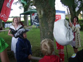 Kids hitting the alarm clock piñata.